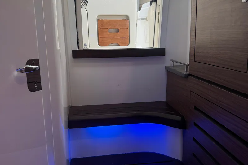  Yacht Photos Pics Interior of 2022 Boston Whaler 350 Realm, featuring sleek wood finishes and ambient blue lighting.