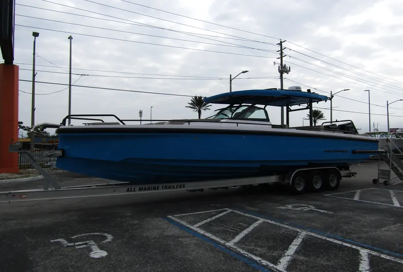  Yacht Photos Pics 2024 Axopar 37 Sun Top boat on trailer in parking lot.