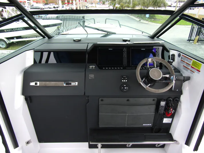  Yacht Photos Pics 2024 Axopar 37 Sun Top helm with modern navigation controls and steering wheel.