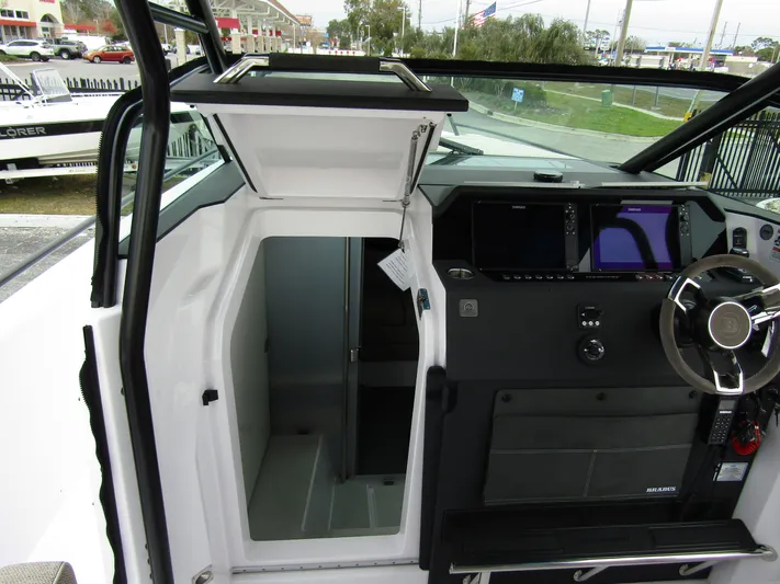  Yacht Photos Pics 2024 Axopar 37 Sun Top interior cockpit with open cabin door and modern dashboard.