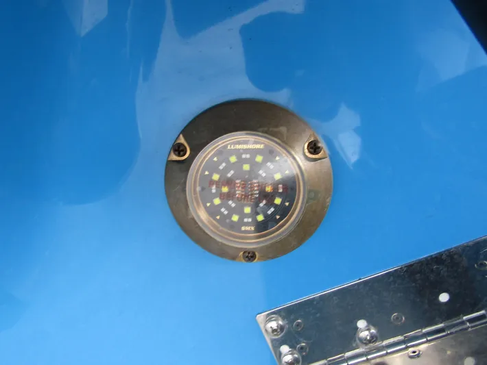  Yacht Photos Pics 2024 Axopar 37 Sun Top boat with a blue hull and underwater LED light.