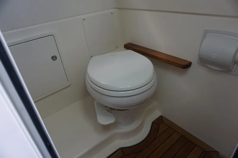 Bwcp0430a424 Yacht Photos Pics 2024 Boston Whaler 380 Outrage boat bathroom with toilet and wooden floor.