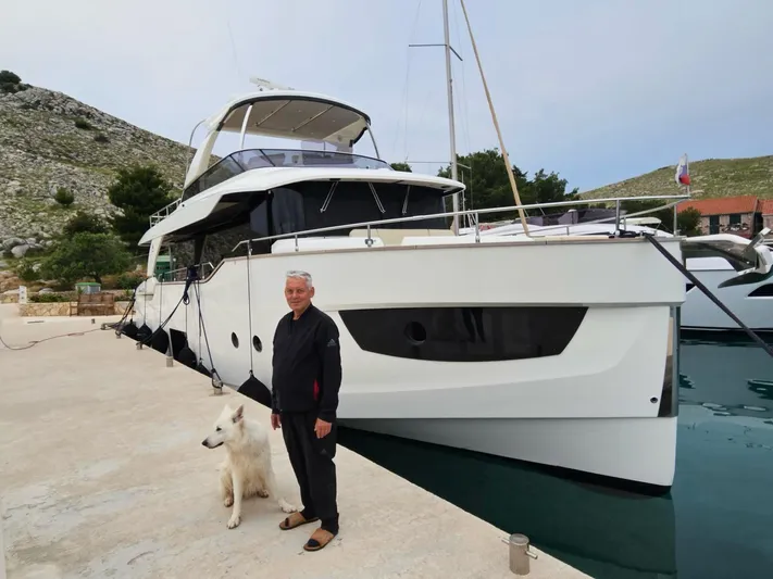  Yacht Photos Pics Man and dog beside 2016 Absolute 58 yacht docked at marina.