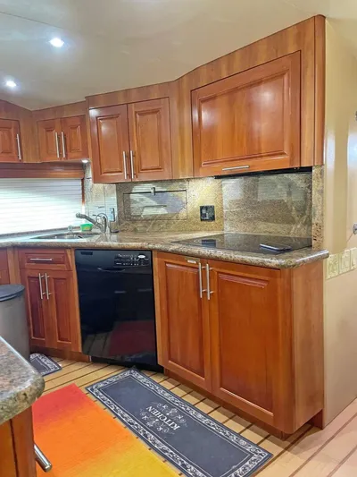  Yacht Photos Pics Luxurious kitchen interior of 2007 Hatteras 68 Convertible yacht with wooden cabinets and granite countertops.