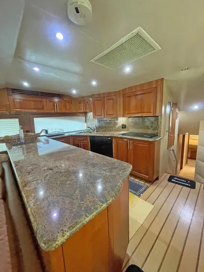  Yacht Photos Pics Luxurious kitchen interior of 2007 Hatteras 68 Convertible yacht with wooden cabinetry.