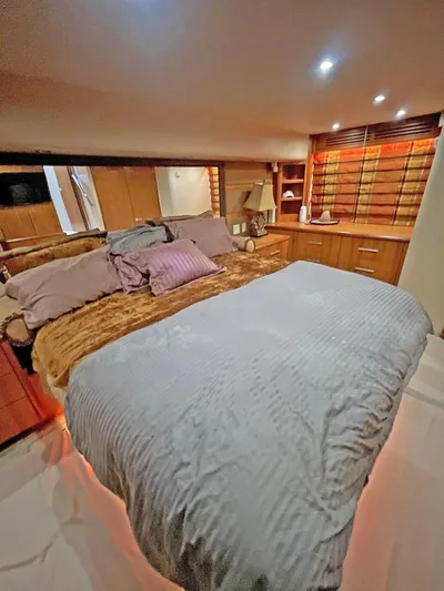  Yacht Photos Pics Luxurious bedroom interior of 2007 Hatteras 68 Convertible yacht with cozy bedding and ambient lighting.