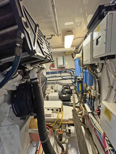  Yacht Photos Pics Engine room of 2007 Hatteras 68 Convertible yacht, showcasing complex machinery and wiring.