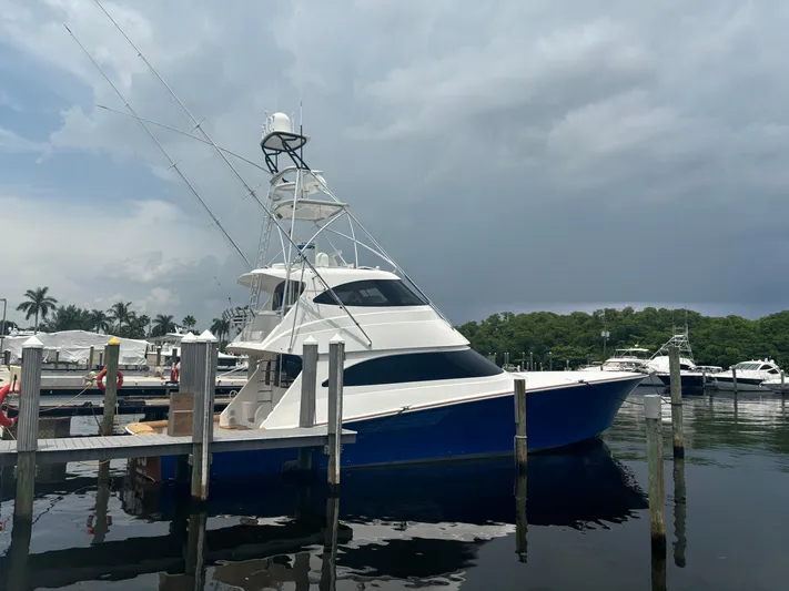 Dry Bones Yacht Photos Pics 2017 Viking 66 Enclosed Bridge yacht docked at marina under cloudy sky.