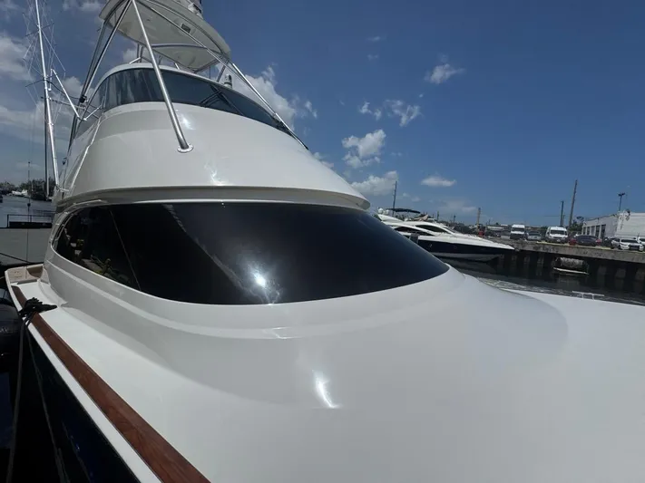Dry Bones Yacht Photos Pics 2017 Viking 66 Enclosed Bridge yacht docked under a clear blue sky.