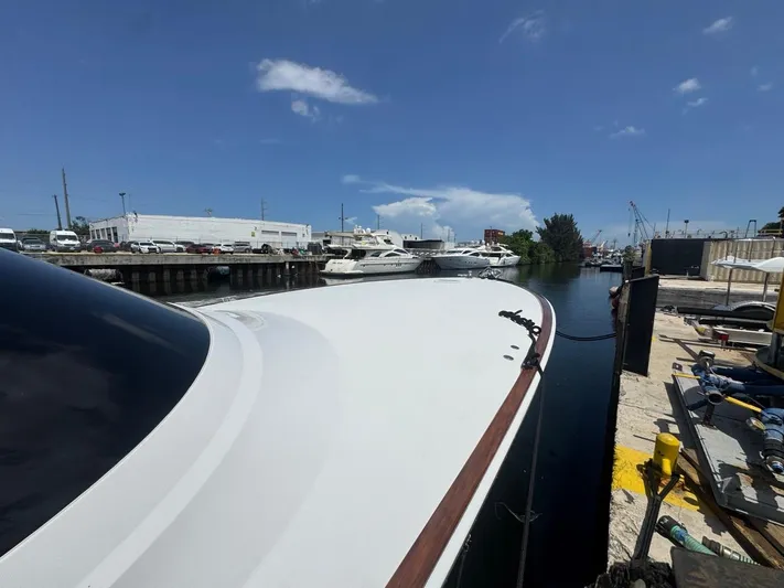 Dry Bones Yacht Photos Pics 2017 Viking 66 Enclosed Bridge yacht docked at a marina under a clear blue sky.