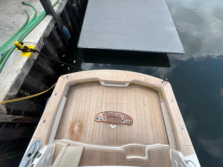 Dry Bones Yacht Photos Pics 2017 Viking 66 Enclosed Bridge yacht docked, showing spacious teak deck and fishing rod holders.