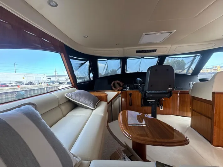 Dry Bones Yacht Photos Pics Luxurious interior of 2017 Viking 66 Enclosed Bridge yacht with plush seating and helm.