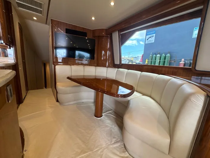 Dry Bones Yacht Photos Pics Luxurious interior of 2017 Viking 66 Enclosed Bridge yacht with plush seating and wood finishes.