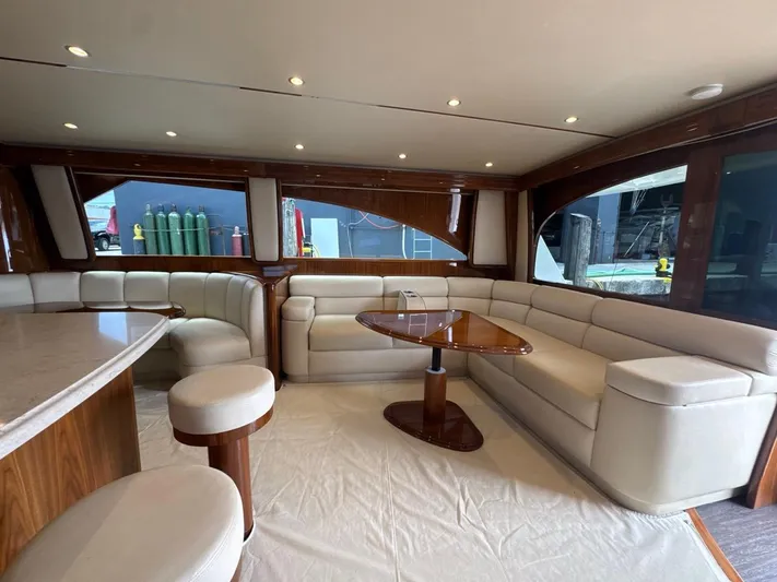 Dry Bones Yacht Photos Pics Luxurious interior of 2017 Viking 66 Enclosed Bridge yacht with elegant seating and table.