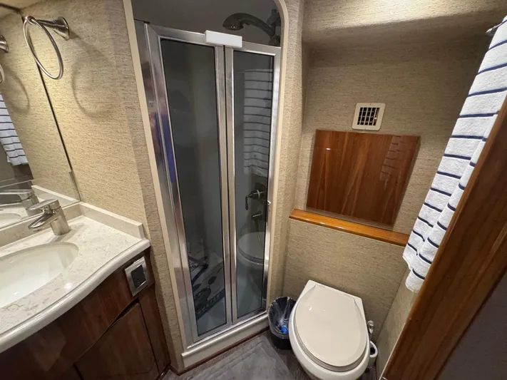 Dry Bones Yacht Photos Pics Bathroom interior of 2017 Viking 66 Enclosed Bridge yacht with shower and toilet.