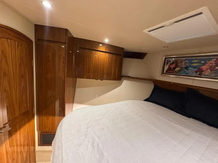 Dry Bones Yacht Photos Pics Luxurious cabin interior of 2017 Viking 66 Enclosed Bridge yacht with wood paneling and artwork.