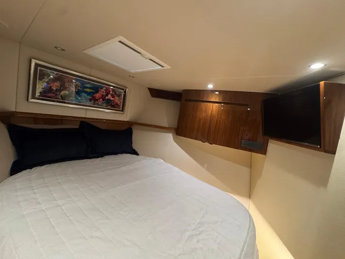Dry Bones Yacht Photos Pics Luxurious bedroom interior of 2017 Viking 66 Enclosed Bridge yacht with cozy bed and TV.