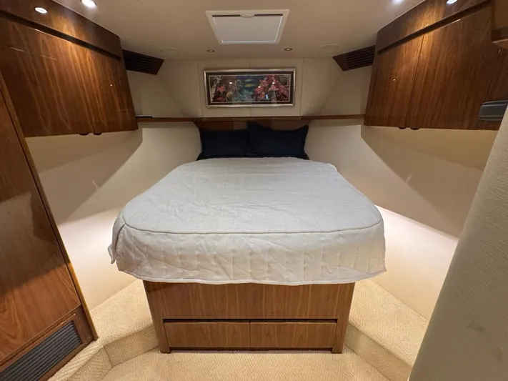 Dry Bones Yacht Photos Pics Luxurious bedroom interior of 2017 Viking 66 Enclosed Bridge yacht with wood cabinetry.
