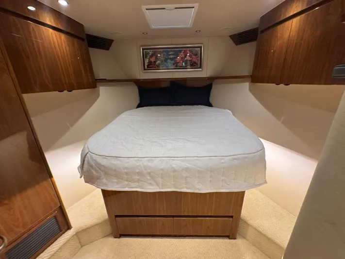 Dry Bones Yacht Photos Pics Luxurious bedroom interior of 2017 Viking 66 Enclosed Bridge yacht with wood cabinetry.