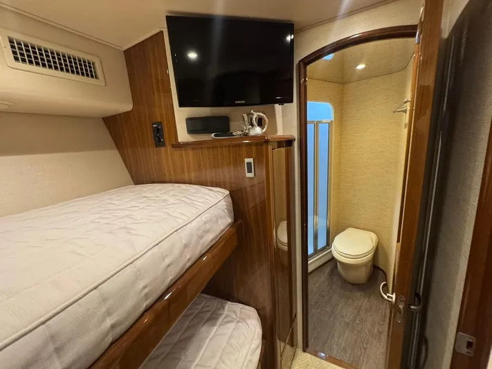 Dry Bones Yacht Photos Pics Interior of 2017 Viking 66 Enclosed Bridge yacht with bunk beds and bathroom.