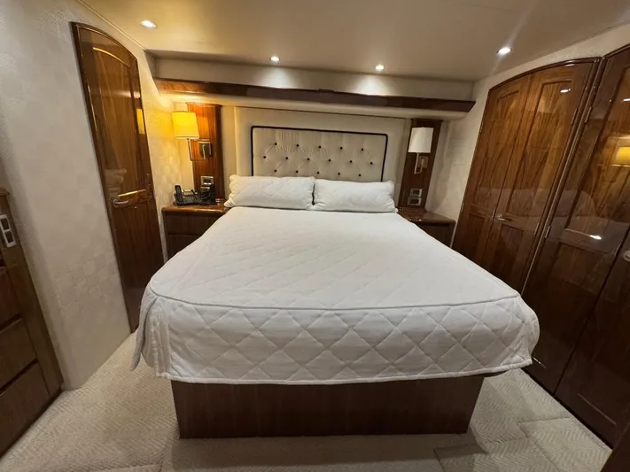 Dry Bones Yacht Photos Pics Luxurious bedroom interior of 2017 Viking 66 Enclosed Bridge yacht with elegant wood finishes.