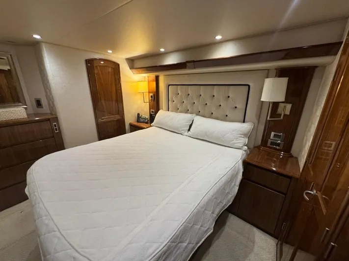 Dry Bones Yacht Photos Pics Luxurious bedroom interior of 2017 Viking 66 Enclosed Bridge yacht with elegant wood finishes.