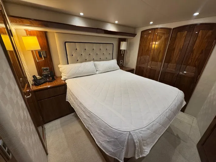 Dry Bones Yacht Photos Pics Luxurious bedroom interior of 2017 Viking 66 Enclosed Bridge yacht with elegant wood finishes.