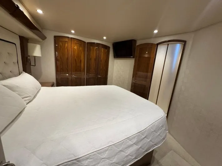 Dry Bones Yacht Photos Pics Luxurious bedroom interior of 2017 Viking 66 Enclosed Bridge yacht with elegant wood finishes.