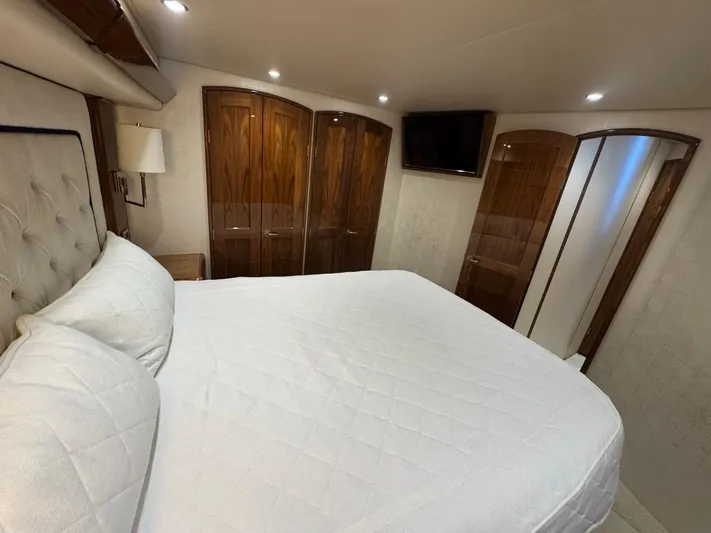 Dry Bones Yacht Photos Pics Luxurious bedroom interior of 2017 Viking 66 Enclosed Bridge yacht with wood accents.