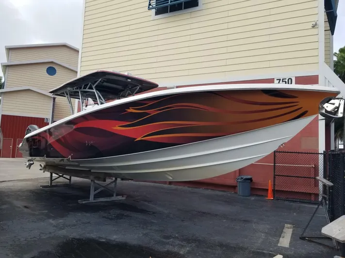 Power Slave Yacht Photos Pics 2020 Nor-Tech Center Console boat with vibrant flame design, docked outdoors.