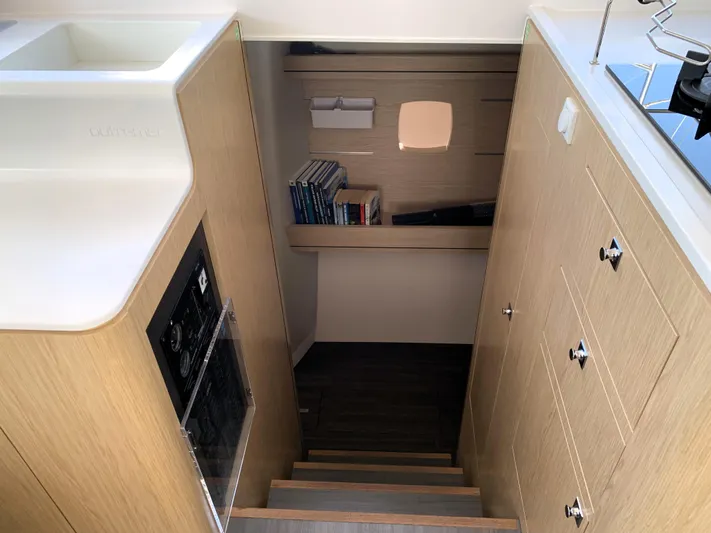 Traverse Yacht Photos Pics Interior of 2021 Outremer 51 yacht, featuring wooden cabinetry and stairs leading to a cozy cabin.