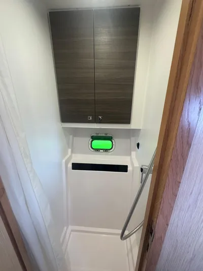 Traverse Yacht Photos Pics Compact bathroom in a 2021 Outremer 51 yacht, featuring a shower and storage cabinets.