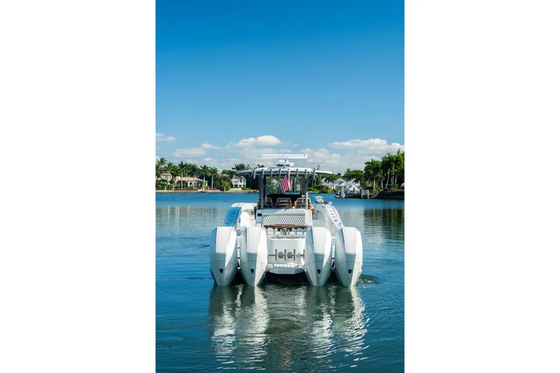  Yacht Photos Pics 2025 Costa Custom Boats 34 on serene water, clear sky, and waterfront homes in the background.