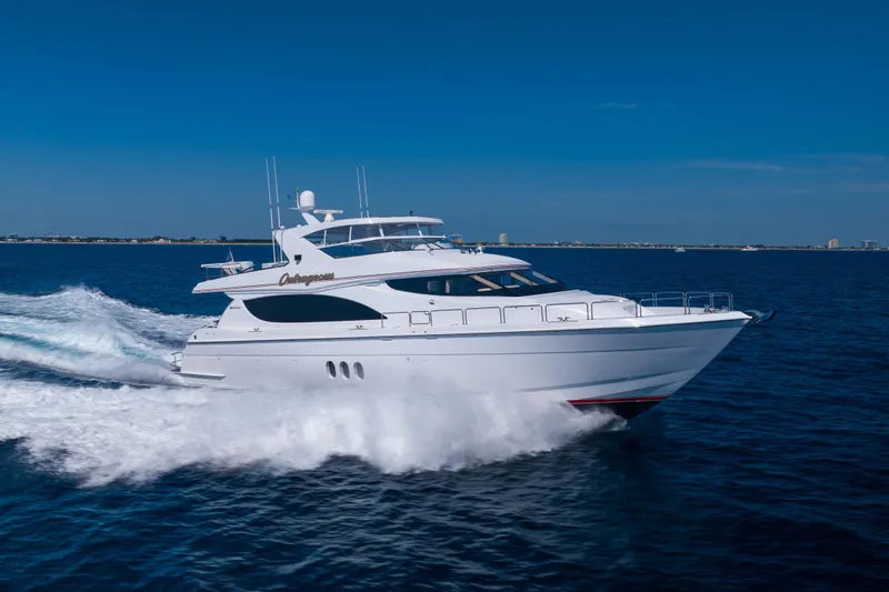 Outrageous Yacht Photos Pics 2005 Hatteras 80 Motor Yacht cruising on open water under clear blue skies.