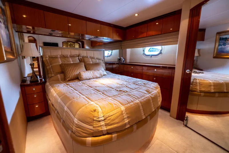 Outrageous Yacht Photos Pics Luxurious bedroom interior of 2005 Hatteras 80 Motor Yacht with elegant bedding and wood finishes.