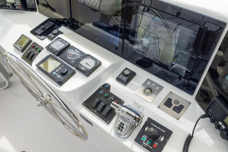 Outrageous Yacht Photos Pics Control panel of a 2005 Hatteras 80 Motor Yacht with navigation instruments and steering wheel.