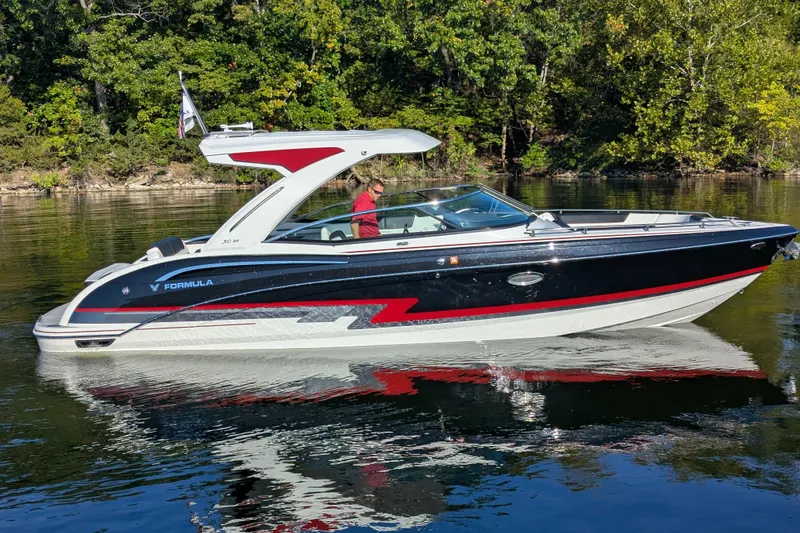 310 Bow Rider Yacht Photos Pics 2021 Formula 310 Bowrider I/O boat cruising on a calm lake with lush green trees.