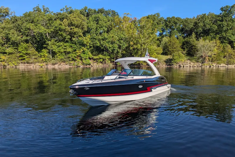 310 Bow Rider Yacht Photos Pics 2021 Formula 310 Bowrider I/O cruising on a serene lake with lush green trees.