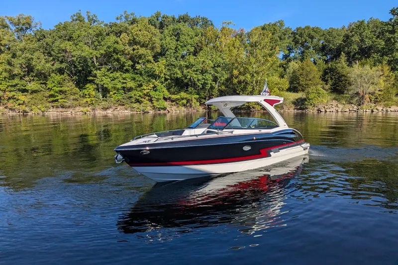 310 Bow Rider Yacht Photos Pics 2021 Formula 310 Bowrider I/O cruising on a serene lake with lush green trees.
