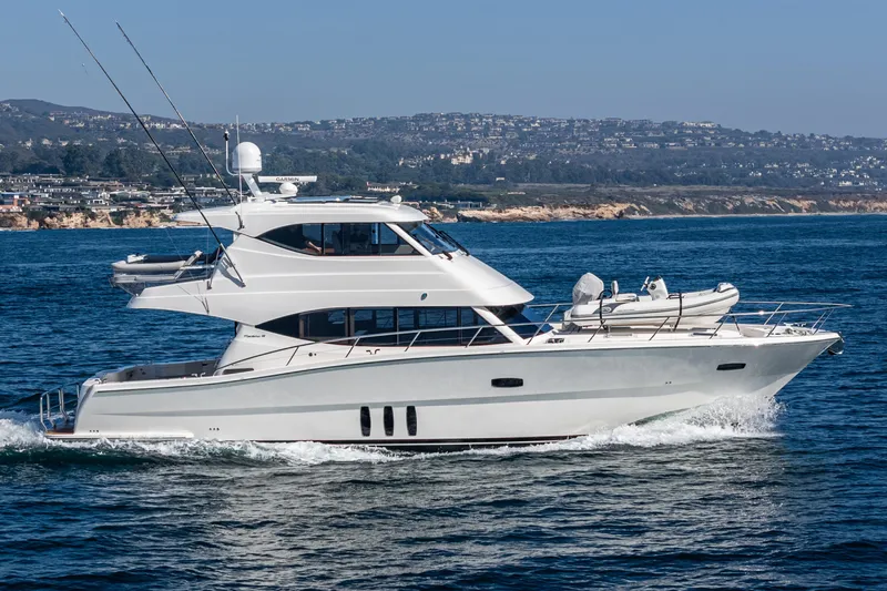 True North Yacht Photos Pics 2020 Maritimo M59 yacht cruising on the ocean near a coastal city.