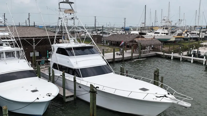 Poco Mas Yacht Photos Pics 1996 Donzi Custom Enclosed Flybridge yacht docked at a marina.