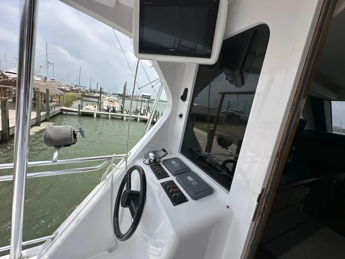 Poco Mas Yacht Photos Pics 1996 Donzi Custom Enclosed Flybridge helm with steering wheel and control panel.