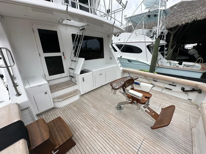 Poco Mas Yacht Photos Pics 1996 Donzi Custom Enclosed Flybridge yacht deck with fishing chair and teak flooring.