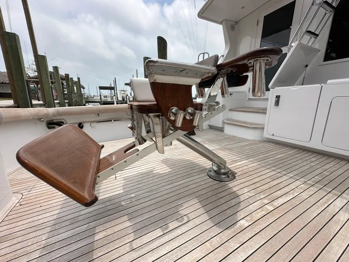 Poco Mas Yacht Photos Pics 1996 Donzi Custom Enclosed Flybridge fishing chair on teak deck.