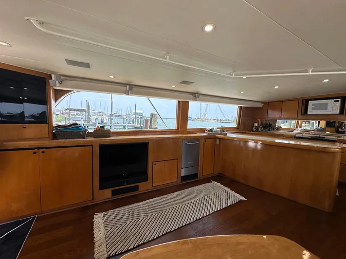 Poco Mas Yacht Photos Pics Interior of 1996 Donzi Custom Enclosed Flybridge yacht with wooden cabinetry and large windows.
