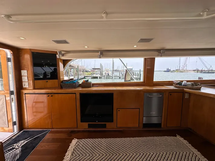 Poco Mas Yacht Photos Pics Interior of 1996 Donzi Custom Enclosed Flybridge yacht with wooden cabinetry and waterfront view.