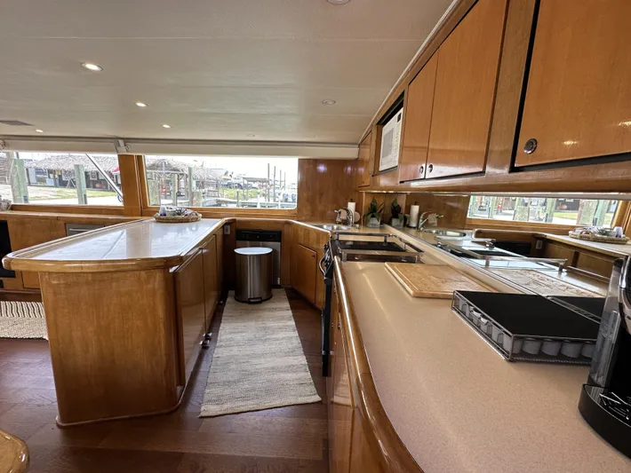 Poco Mas Yacht Photos Pics 1996 Donzi Custom Enclosed Flybridge kitchen with wooden cabinetry and modern appliances.