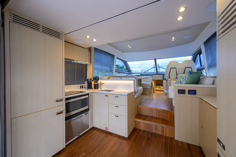  Yacht Photos Pics Luxurious interior of 2022 Princess F50 yacht with modern kitchen and seating area.