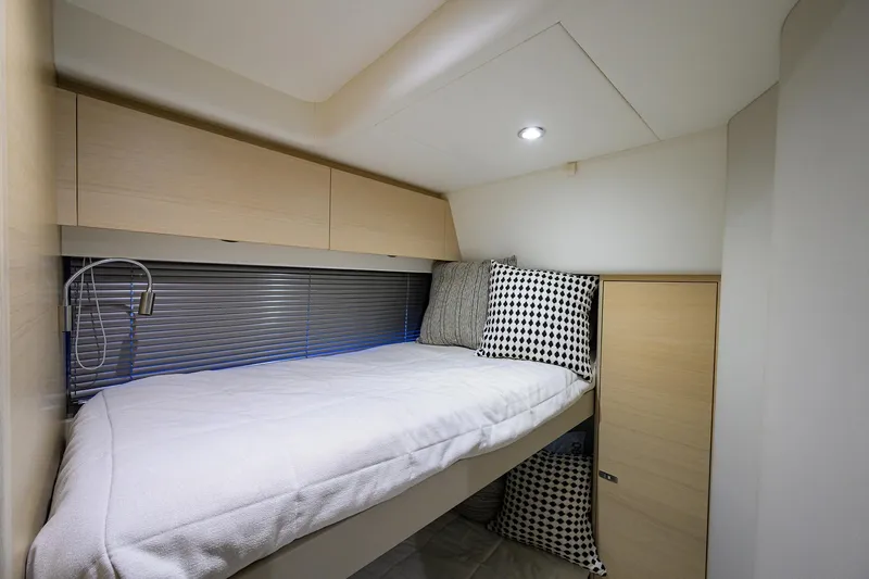  Yacht Photos Pics Cozy cabin interior of 2022 Princess F50 yacht with modern bedding and storage.