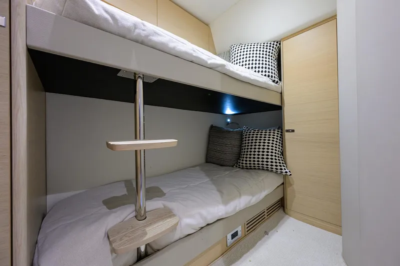  Yacht Photos Pics Bunk beds in 2022 Princess F50 yacht cabin with modern decor and checkered pillows.